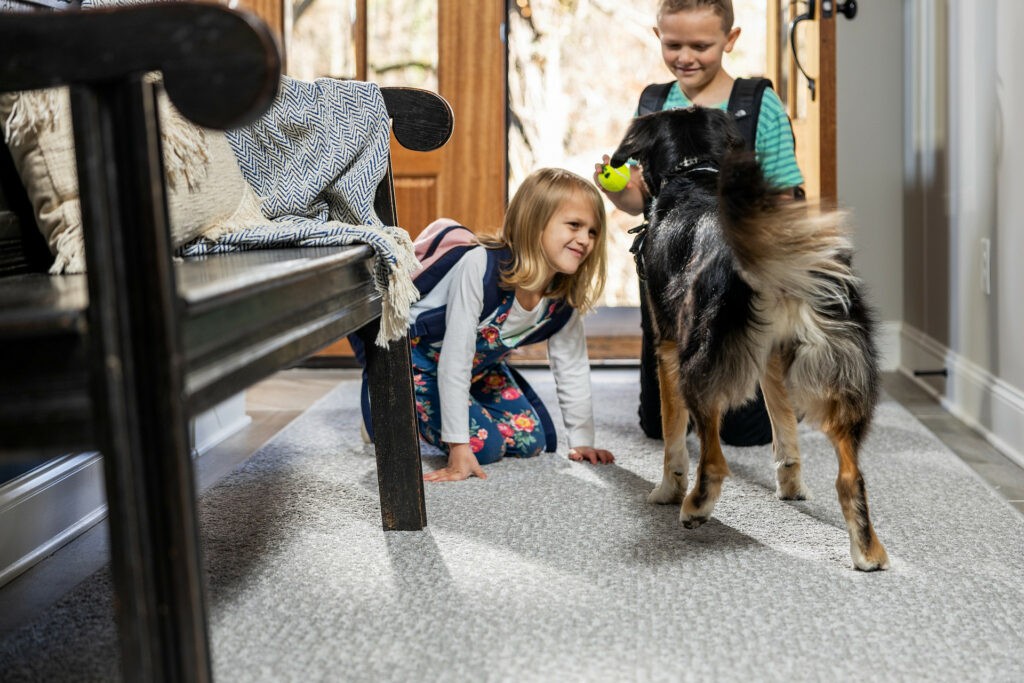 Kids playing with dog on carpet floor | Country Manor Decorating